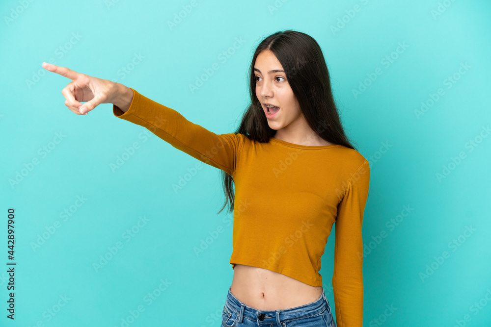 Young French woman isolated on blue background pointing away