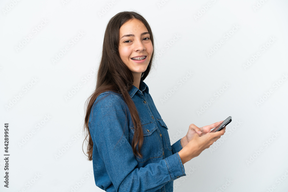 Young French girl isolated on white background sending a message or email with the mobile Young French girl isolated on white background sending a message or email with the mobile