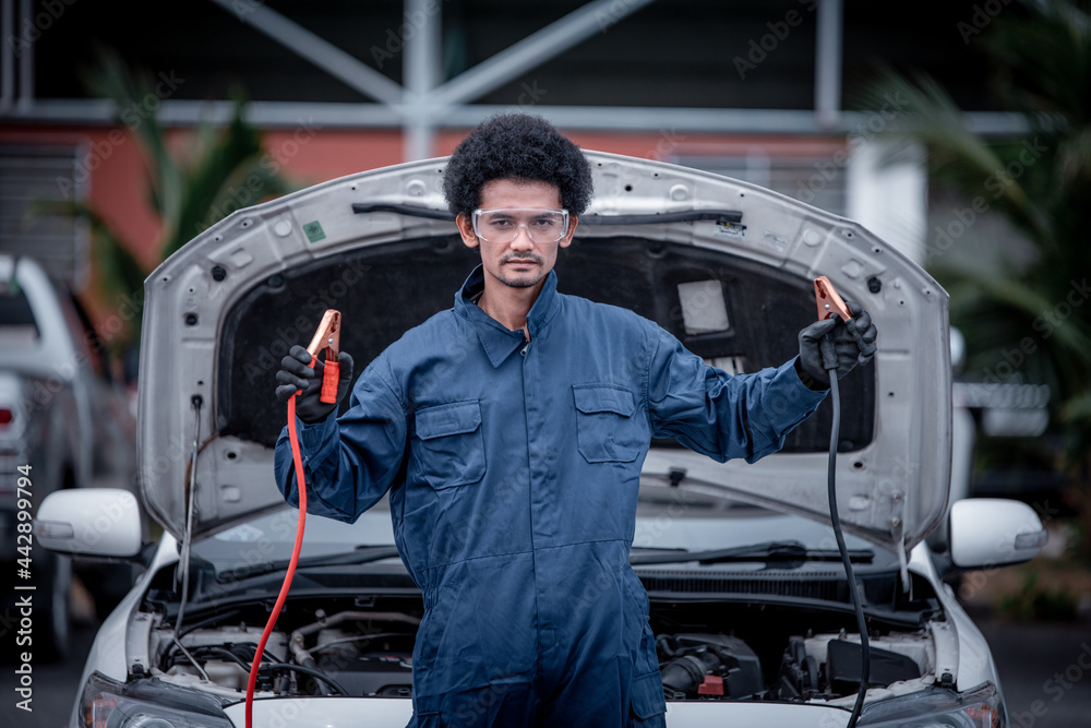 Car mechanic under repairing car open hood checking electric line car system and clean in car garage service. Car mechanic under repairing car open hood checking electric line car system and clean in car garage service.
