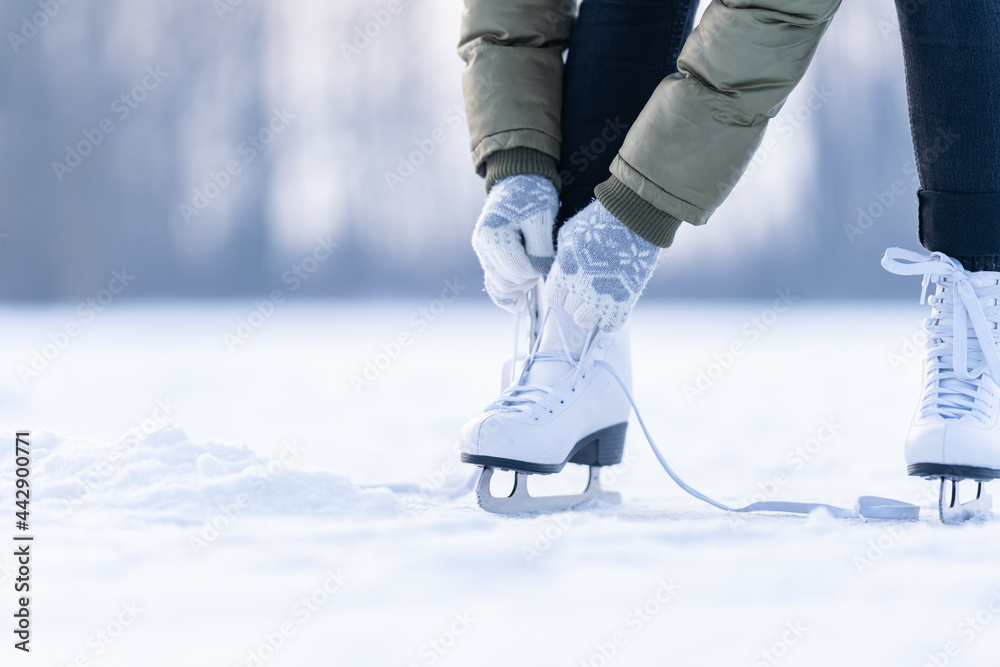 tying the laces of winter skates on a frozen lake, ice skating