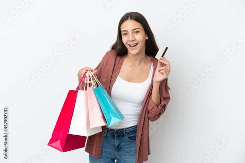 Young French girl isolated on white background holding shopping bags and a credit card