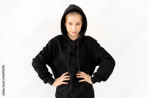 Beautiful girl in hoodie posing with hands on waist
