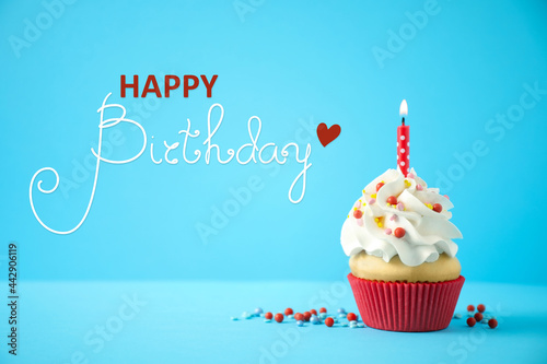 Happy Birthday  Delicious cupcake with candle on light blue background