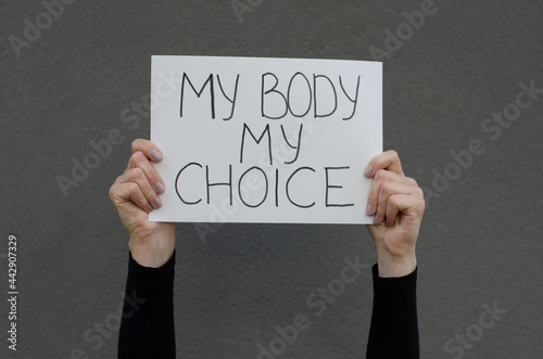 Female hands holding a protest a sign reading My Body My Choice Female right on legal abortion. Human rights freedom