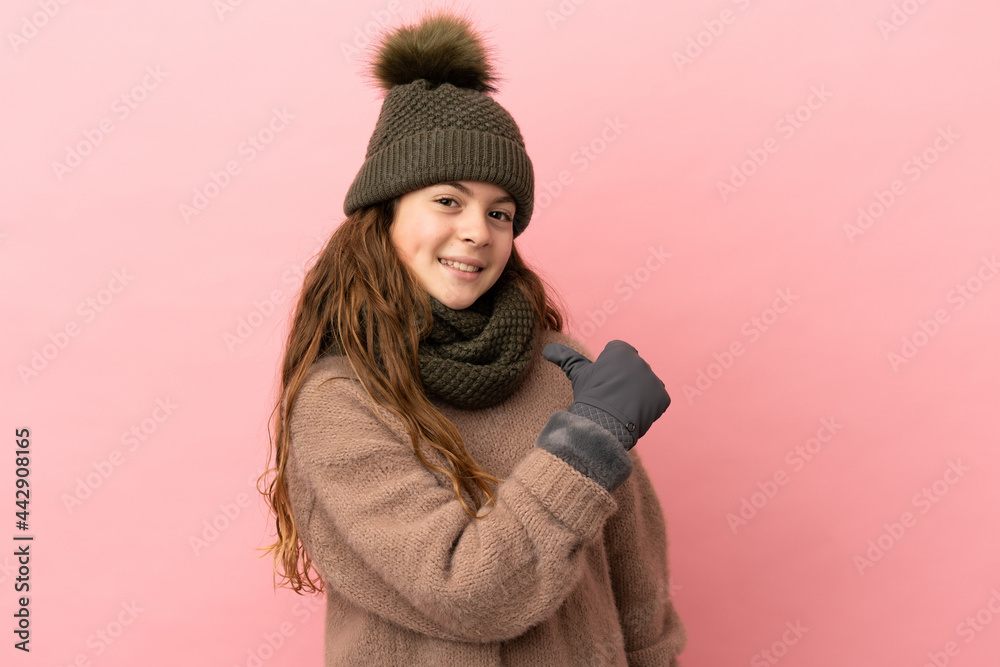 Little girl with winter hat isolated on pink background proud and self-satisfied Little girl with winter hat isolated on pink background proud and self-satisfied