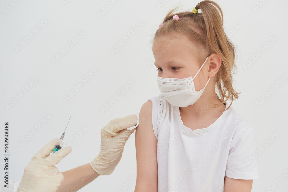 A little girl is afraid of vaccinations, injections and vaccinations. The child is being vaccinated against the coronavirus
