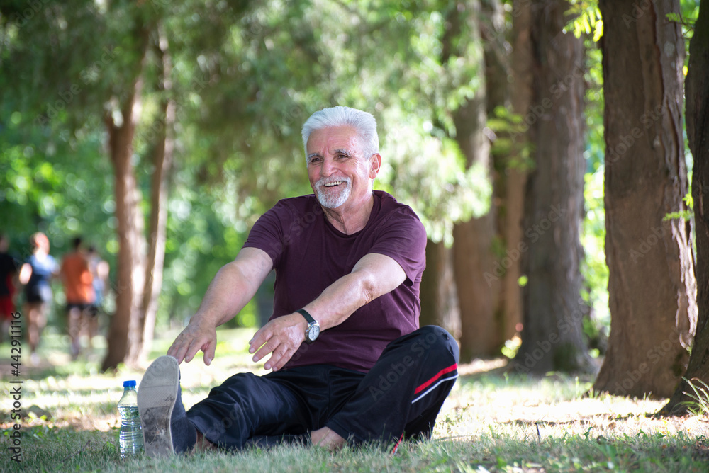 Senior jogger by lake in morning time stretching