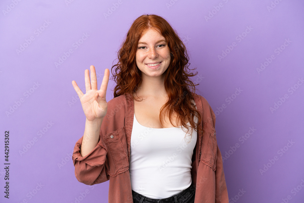 Fototapeta premium Teenager redhead girl over isolated purple background happy and counting four with fingers