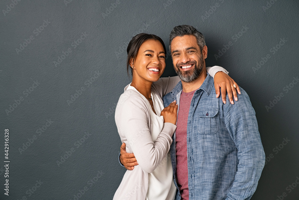 Mature multiethnic couple embracing and smiling together - obrazy, fototapety, plakaty 