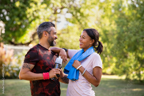 Slika na platnu Mixed race couple taking a break after jog at park
