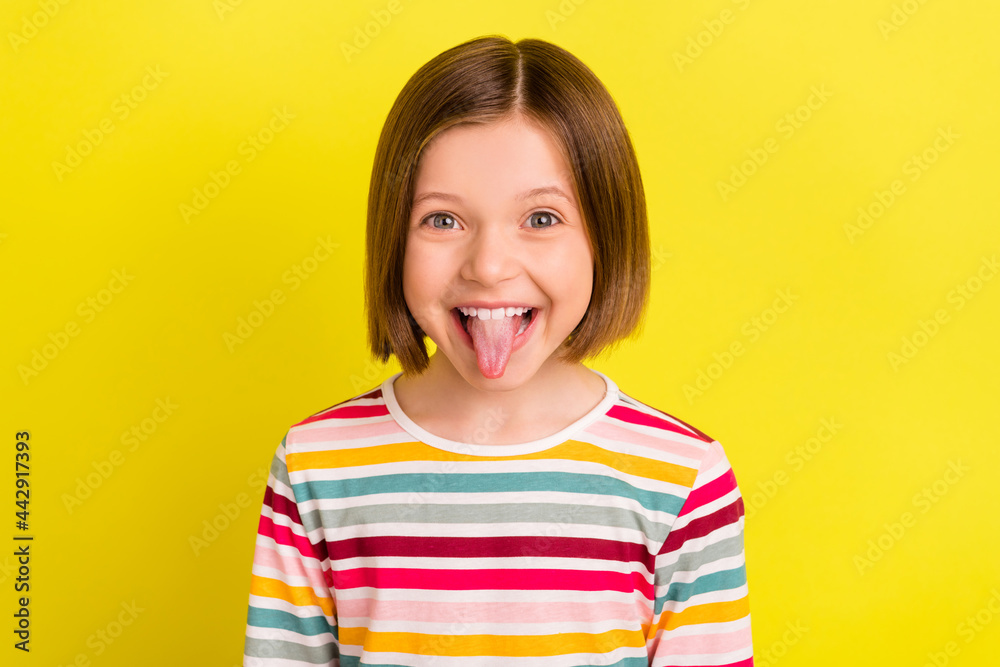 Photo portrait small girl fooling showing tongue grimacing isolated vibrant yellow color background Photo portrait small girl fooling showing tongue grimacing isolated vibrant yellow color background