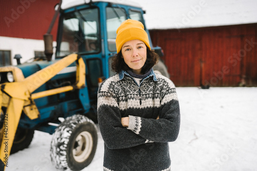 Porträtt av leende kvinna med armarna i kors stående utomhus photo