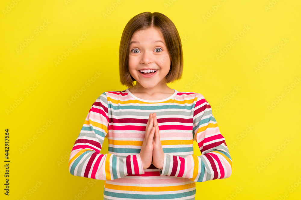 Photo of happy nice young adorable small girl hold hands clap present isolated on yellow color background Photo of happy nice young adorable small girl hold hands clap present isolated on yellow color background