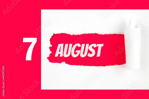 August 7th. Day 7 of month, Calendar date. Red Hole in the white paper with torn sides with calendar date. Summer month, day of the year concept. photo