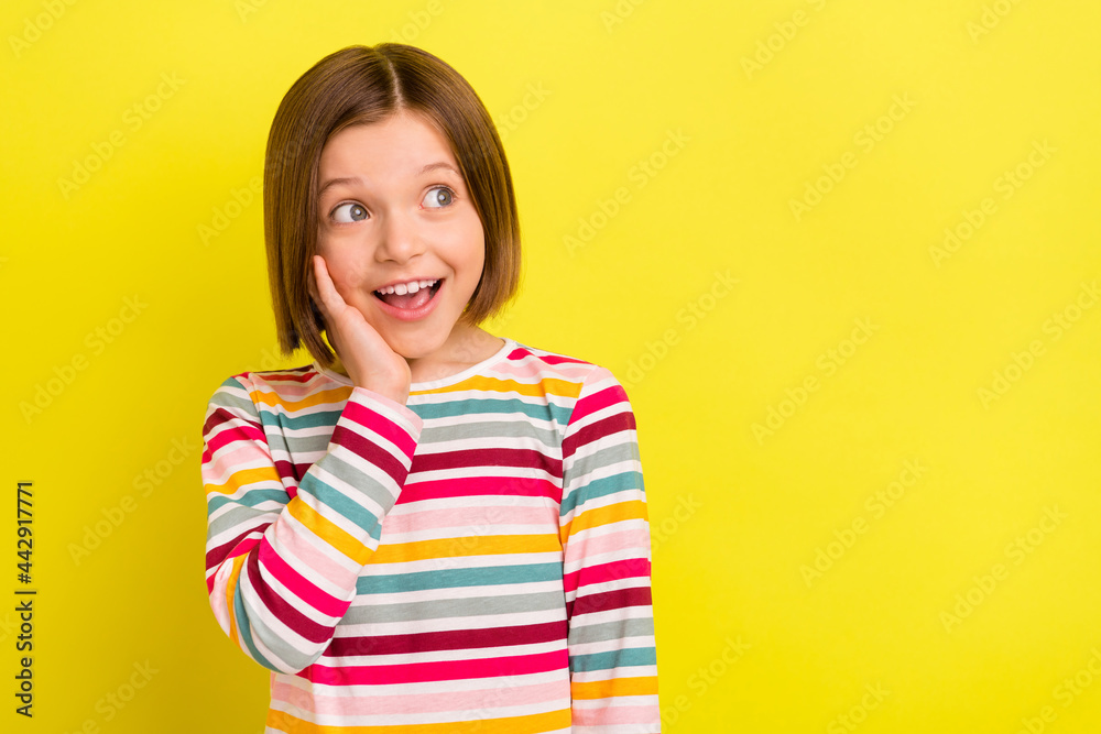 Photo portrait little girl in with bob hairstyle amazed touching cheek looking copyspace isolated vivid yellow color background Photo portrait little girl in with bob hairstyle amazed touching cheek looking copyspace isolated vivid yellow color background
