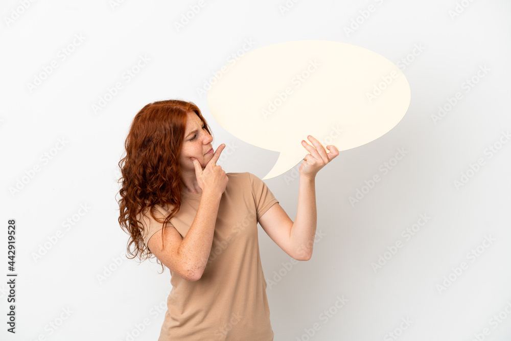 Teenager redhead girl isolated on white background holding an empty speech bubble and thinking Teenager redhead girl isolated on white background holding an empty speech bubble and thinking