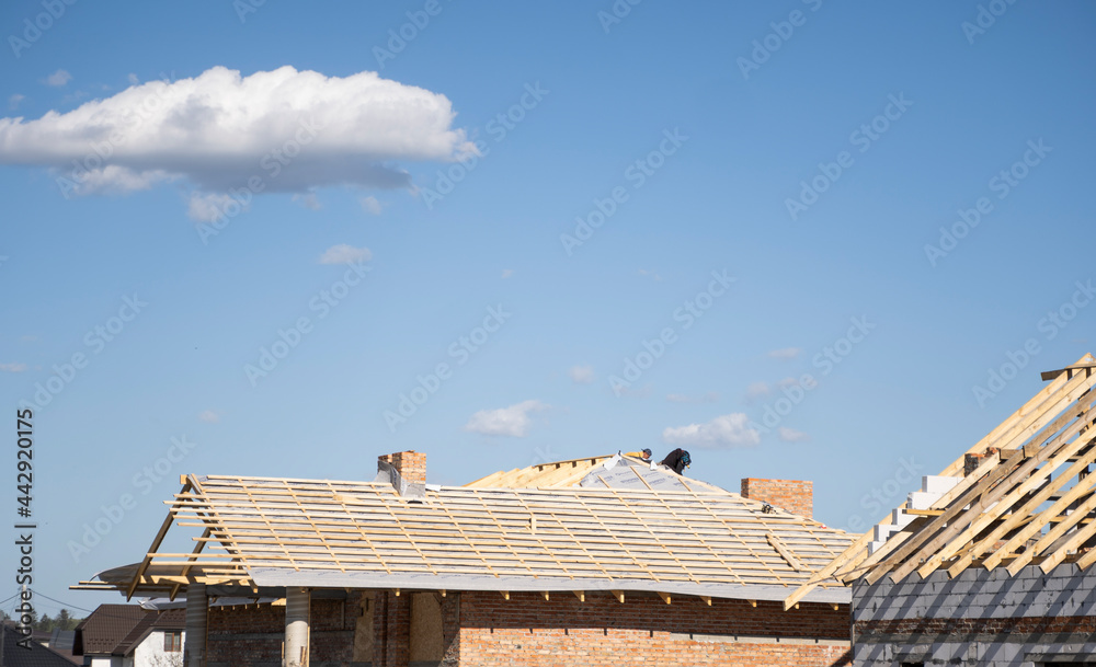 Wooden roof construction against blue sky. House building.