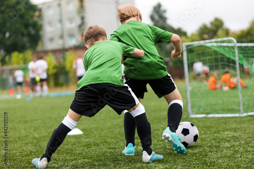 Two Boys Compete on Soccer Football Training. Happy Kids Practicing Sports on School Soccer Venue. Sports Activities For School Kids on Summer Time © matimix