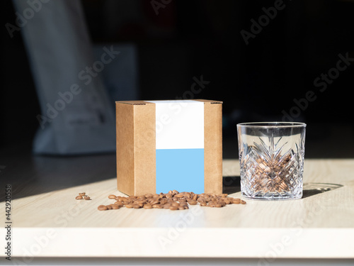 mockup box of coffee. A box of coffee in the sun. A glass cup of coffee. Coffee Packaging