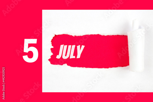 July 5th. Day 5 of month, Calendar date. Red Hole in the white paper with torn sides with calendar date. Summer month, day of the year concept. photo