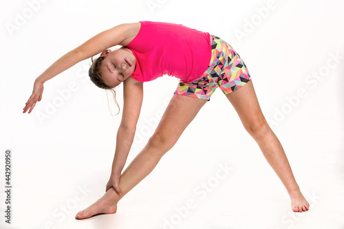 A tween girl doing a side stretch.