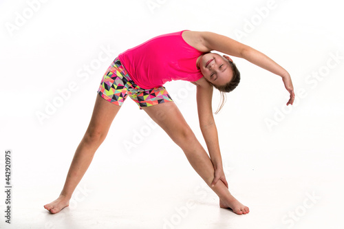A tween girl doing a side stretch.