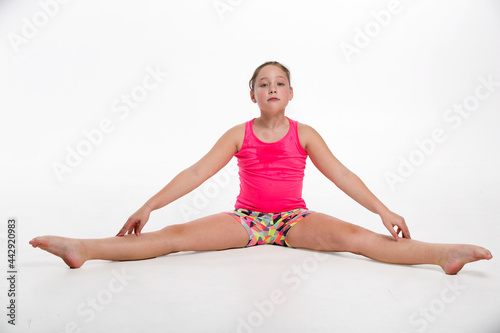 A young tween girl streching for a dance routine.