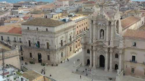 Beautiful drone view of Siracusa Dome Square with a priest statue and the blue mediterranean sea in the back, with a lovely summer day in Sicily, Italy.