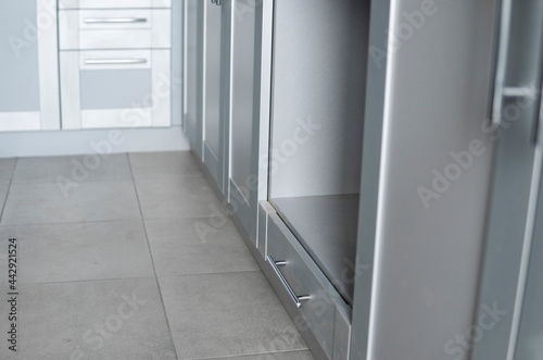 Modern minimalist style kitchen close up in monochrome tones. Custom kitchen with grey white facades mdf and dark grey countertop. Modular kitchen from chipboard.