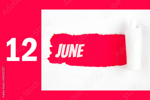 June 12nd. Day 12 of month, Calendar date. Red Hole in the white paper with torn sides with calendar date. Summer month, day of the year concept. photo