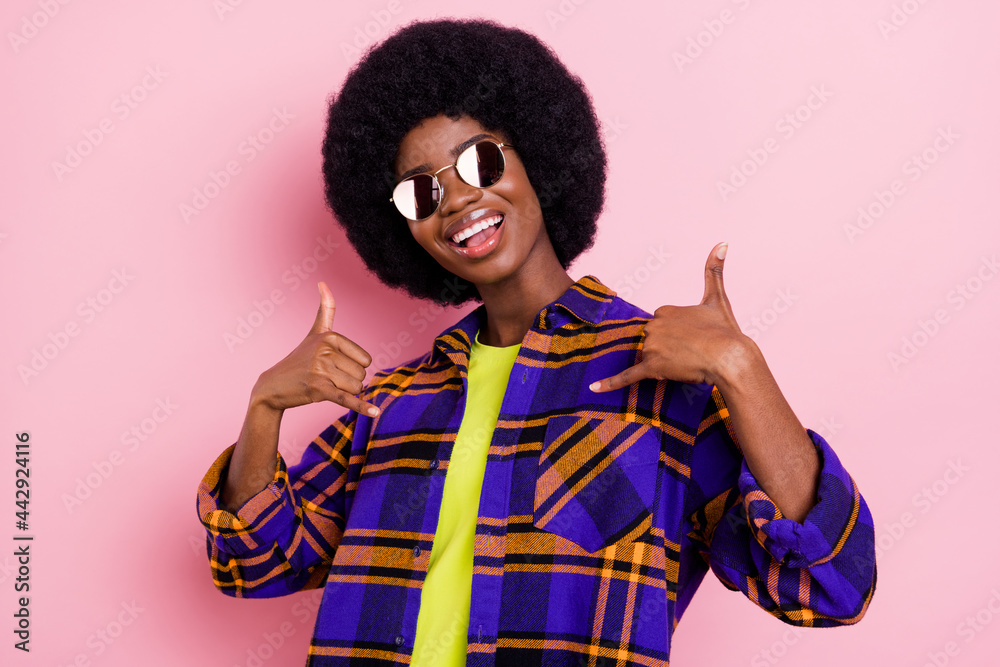 Portrait of attractive cheerful funky girl showing call me sign symbol having fun isolated over pink pastel color background Portrait of attractive cheerful funky girl showing call me sign symbol having fun isolated over pink pastel color background