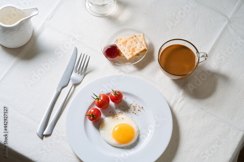 Fried egg with tomatoes on white plate  breakfast dining table