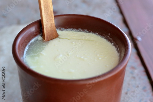 closeup of soured milk in brown clay cup