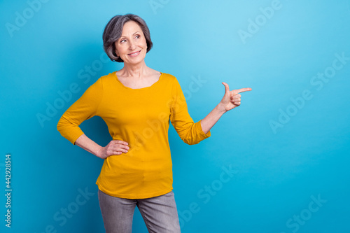 Portrait of attractive curious cheerful woman showing copy space ad advert subscribe isolated over vivid blue color background