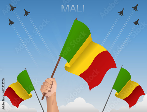 The flags of Mali fly under the blue sky