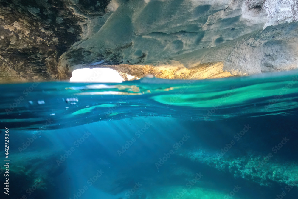 Underwater sea level split photo of iconic caves of Sarakiniko a geological volcanic white rock chalk resembling lunar scenery, Milos island, Cyclades, Greece