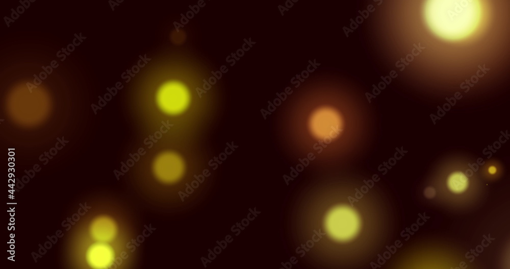 Image of yellow glowing spots of light moving in hypnotic motion on black background Image of yellow glowing spots of light moving in hypnotic motion on black background