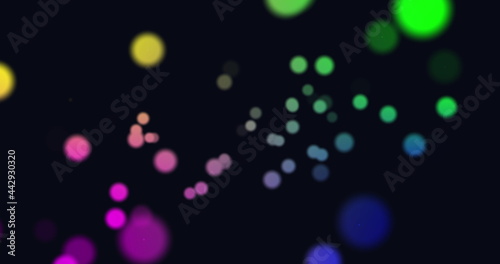 Image of multi coloured glowing spots of light moving in hypnotic motion on black background
