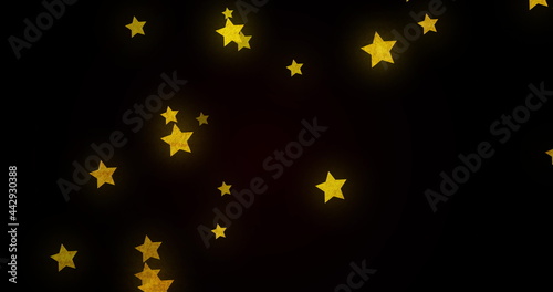 Image of glowing golden stars twinkling and moving in hypnotic motion on black background