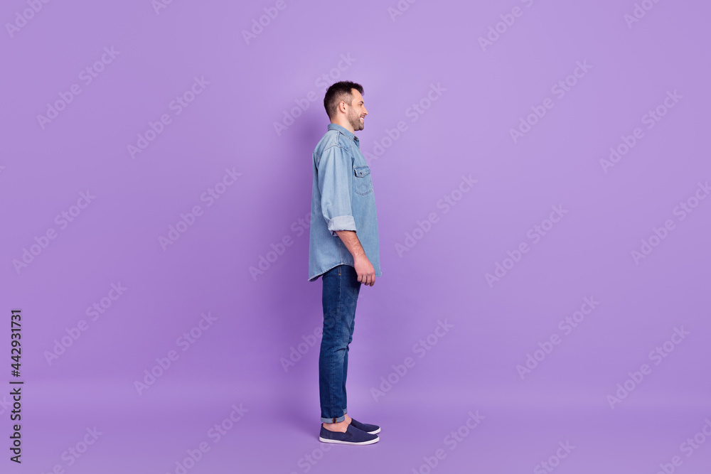 Full length body size photo man wearing denim clothes looking blank space isolated pastel violet color background Full length body size photo man wearing denim clothes looking blank space isolated pastel violet color background