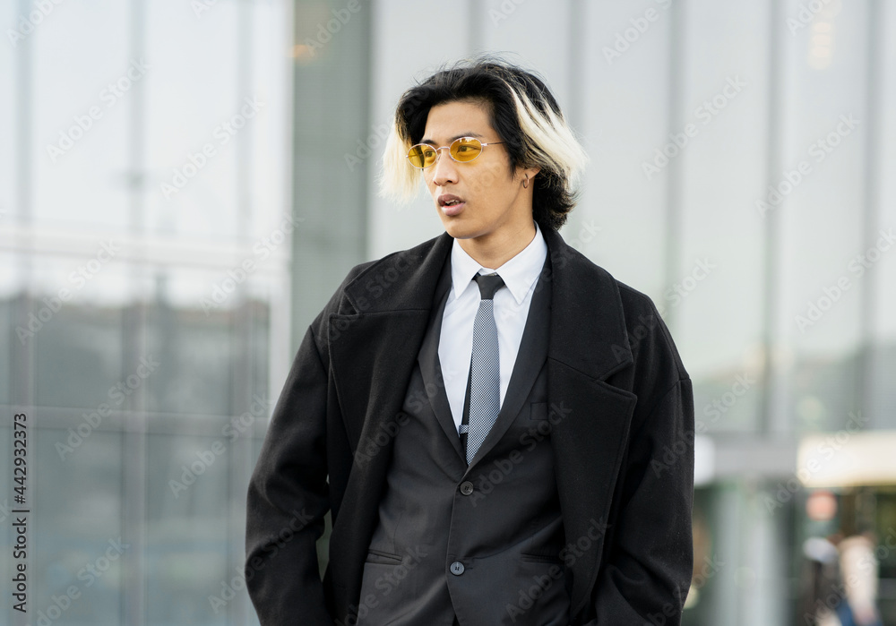 Confident Asian businessman in stylish wear on urban pavement Confident Asian businessman in stylish wear on urban pavement