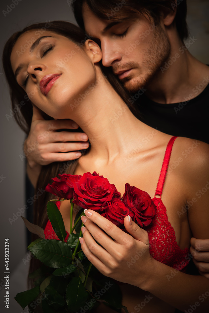 sexy woman with red roses near young man embracing her at night Stock Photo  | Adobe Stock