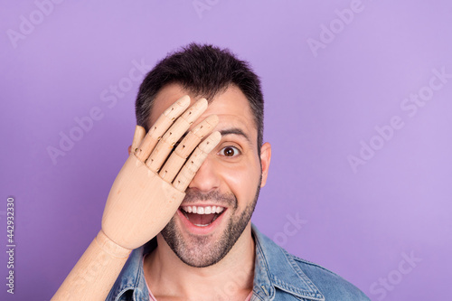 Photo of young guy happy positive smile close cover eye wooden hand prosthesis isolated over purple color background photo