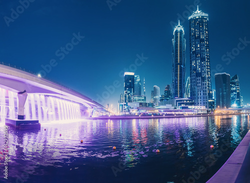 Illuminated waterfall bridge in downtown Dubai at night with thousands of small lights on high skyscrapers. Popular tourist attractions in UAE