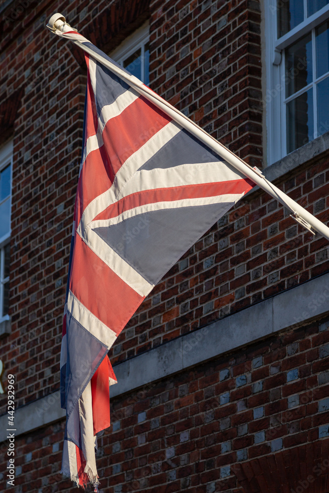 A union jack flag flying outside a brick building