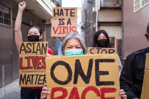Asian protesters in face masks with placards on city street