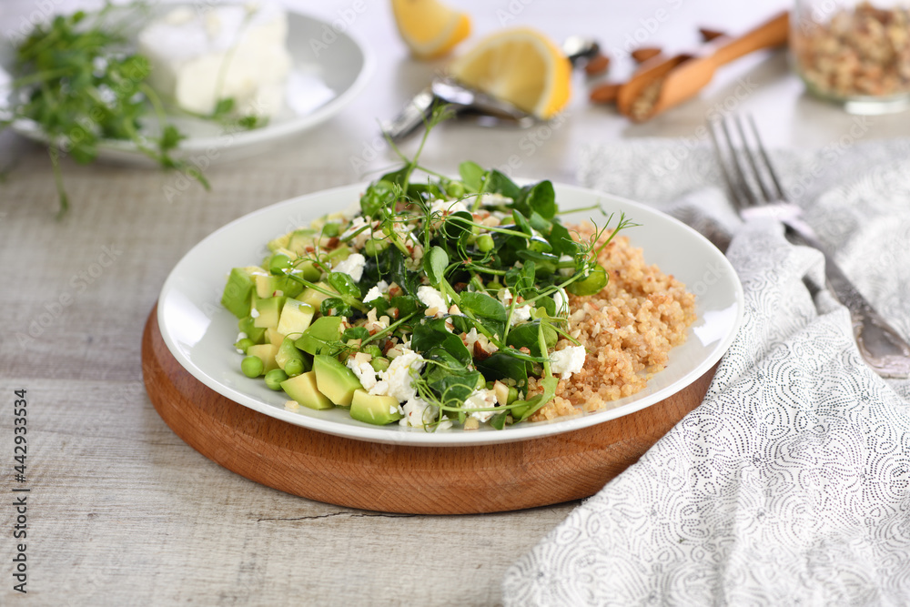 Gluten-free green vegetarian salad made of microgreen sprouts peas, avocado, quinoa, spinach, seasoned crushed almonds with slices of feta cheese Gluten-free green vegetarian salad made of microgreen sprouts peas, avocado, quinoa, spinach, seasoned crushed almonds with slices of feta cheese