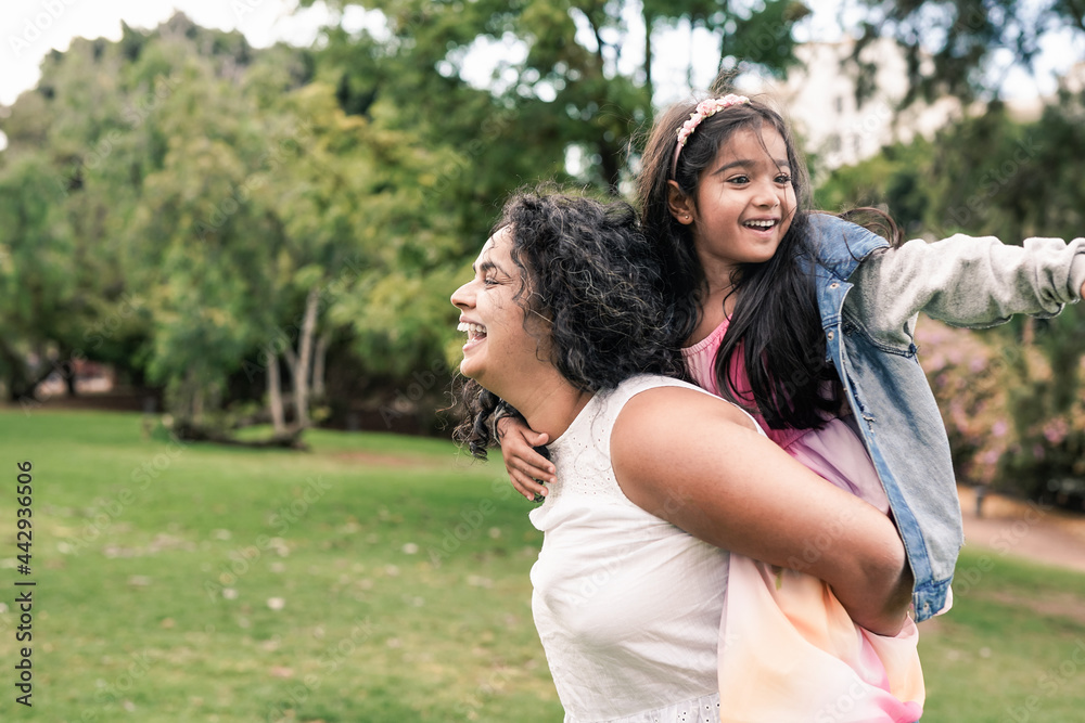 Fototapeta premium Indian mother and child having playful time at city park - Family love concept