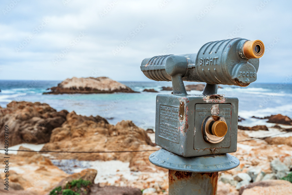Tourist stationary observation binoculars for viewing rocks in the Pacific Ocean on the coast of California