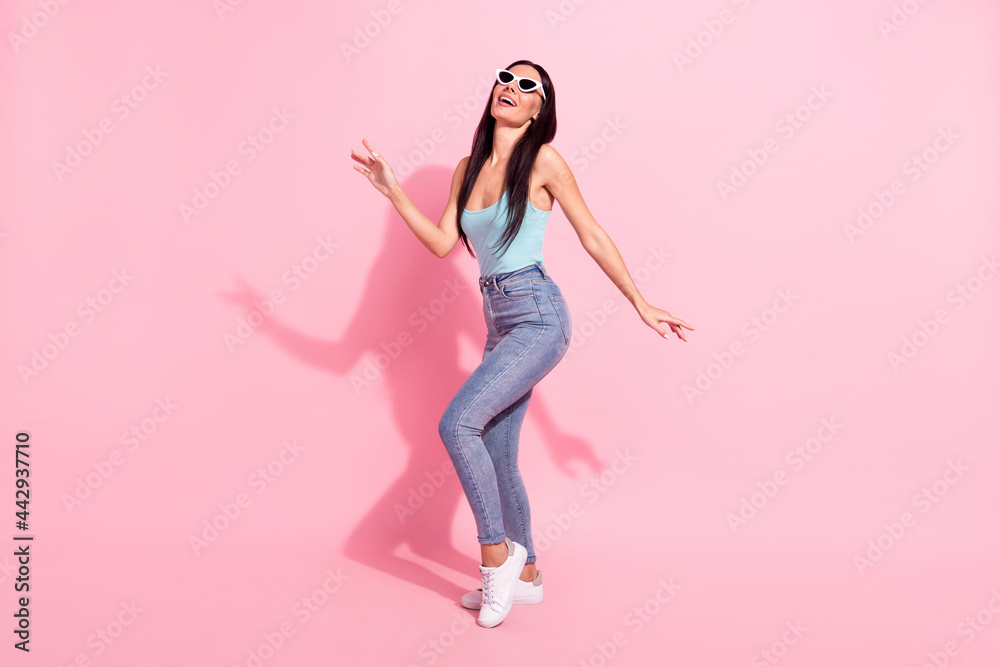 Full length body size photo of smiling woman wearing sunglass laughing overjoyed isolated on pastel pink color background